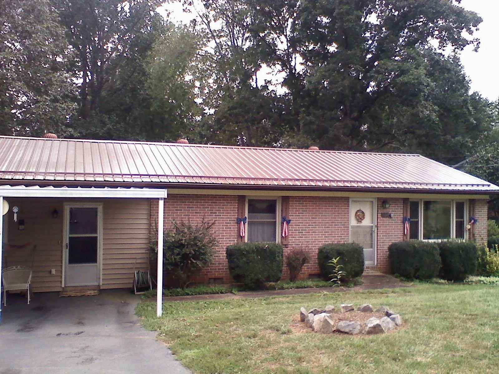 Bronze metal roof and carport on a brick ranch home — Roof Repair work by our crew in Canton